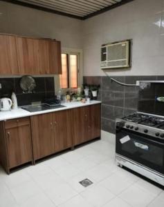 cocina con armarios de madera y horno con fogones en 3 Bedroom Apartment en Makkah