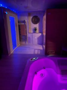 ein Badezimmer mit einer rosa Badewanne in einem lila Zimmer in der Unterkunft Golden Crown exclusive use spa venue in Tarbolton