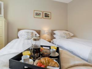 a room with two beds and a tray of food at The Barn At Grislow Field in Baslow