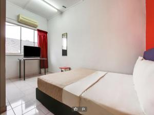 a bedroom with a bed and a desk with a computer at T FAMILY HOTEL in Klang