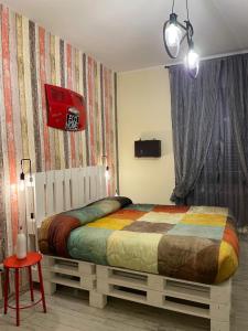 ポテンツァにあるAlloggio Turistico Eco Homeのベッドルーム1室(カラフルな毛布付きのベッド1台付)