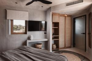 1 dormitorio con 1 cama, TV y ventana en Myra Hotel, en Kavala
