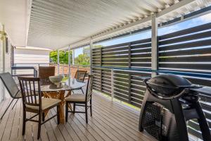 balcón con mesa, sillas y bicicleta en Oceanfront Sandy Beach Couples Getaway, en Emerald Beach