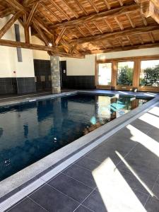 a large swimming pool in a building with a ceiling at Three bedroom Apartment, Samoens, Grand Massif in Samoëns