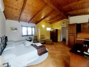 マリーナ・ディ・カメロータにあるParco Esmeralda - Family Residence e Breakfastの木製の天井、大きな白いベッドが備わるベッドルーム1室が備わります。
