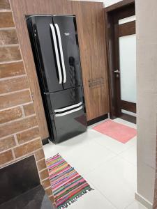 einen schwarzen Kühlschrank in einem Zimmer mit Ziegelwand in der Unterkunft Duplex Maisonette with roof in Fgura