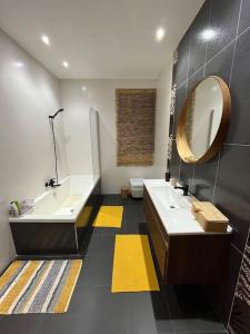 ein Badezimmer mit 2 Waschbecken und einem Spiegel in der Unterkunft Duplex Maisonette with roof in Fgura