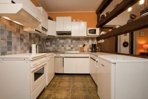 een keuken met witte kasten en witte apparaten bij Ferienwohnungen Salmen in Pörtschach am Wörthersee