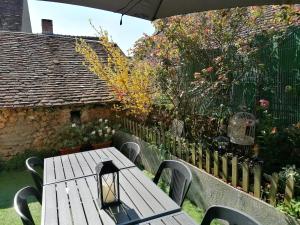 einem Picknicktisch mit einer Lampe und einem Zaun in der Unterkunft La Gouline in Gréez-sur-Roc