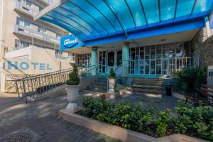 a building with a blue roof and a bench at Hotel Lawrence in Foz do Iguaçu