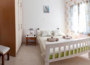 1 dormitorio con cama blanca y ventana en Villa Oz IPS Kokkino Chonrio, en Kókkinon Khoríon