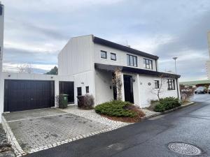 a white house with a garage on a street at Cosy and family friendly house in Reykjavik centrally located in Laugardalur in Reykjavík