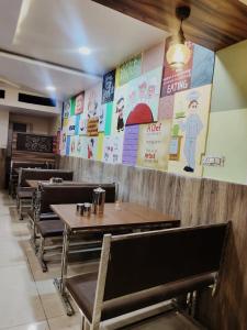 a restaurant with tables and chairs and signs on the wall at Anand Mahal Hotel in Nagpur