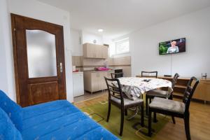 a living room with a table and chairs and a kitchen at Apartman Zelengora in Tjentište