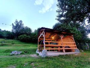 una pequeña cabaña de madera en un campo de hierba en Manoni Ratiani's Guesthouse, en Mestia