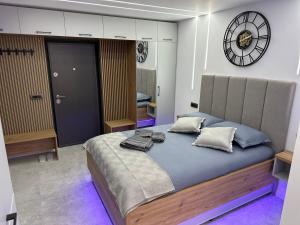 a bedroom with a large bed and a clock on the wall at FANTASY ROOM in Iaşi