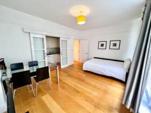 1 dormitorio con 1 cama, mesa y sillas en Deluxe Entire Apartment Between Covent Garden and St Pauls Cathedral en Londres