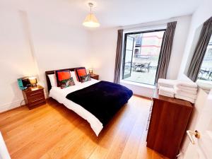 um quarto com uma cama e uma grande janela em Deluxe Entire Apartment Between Covent Garden and St Pauls Cathedral em Londres