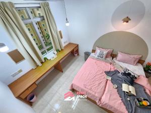 a small bedroom with a pink bed and a window at Ixora Coliving Lifestyle Homestay in Ayer Keroh +28 photos