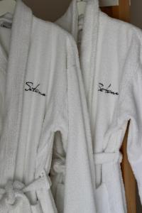 two white towels with black writing on them at Hotel Sa Tuna in Begur