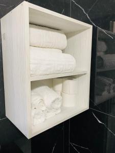 a wooden cabinet with towels and toiletries in a bathroom at Gerasimos in Menídion