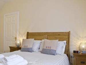 een slaapkamer met een bed met witte lakens en kussens bij Hedderwick House in Pittenweem