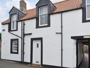 a white and black house with a red roof at Hedderwick House in Pittenweem