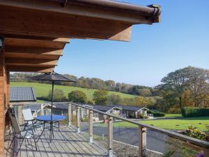 una terraza con mesa, sillas y sombrilla en Lodge 3 en Kinlet