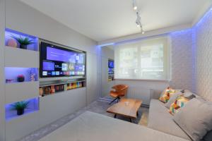 een woonkamer met een bank en een tv bij Liberty in Zagreb