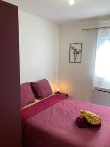 um quarto com uma cama com um cobertor roxo em Marie Louise em Montreuil