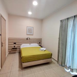a bedroom with a bed with a yellow blanket at Minos Studios in Chania