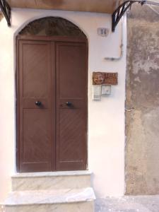 una grande porta di legno sul lato di un edificio di B&B Mediterraneo a Gela