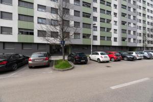 een parkeerplaats met auto's geparkeerd voor een groot gebouw bij Liberty in Zagreb +10 foto's