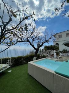 a swimming pool in a yard with a tree at Villa Marunnella in Praiano