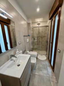 une salle de bain avec un lavabo, des toilettes et une douche dans l'établissement Becky's House casa vacanze, à Quartu SantʼElena