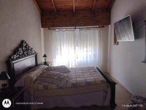 a bedroom with a bed in front of a window at Mi casita in Tandil