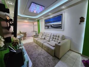 uma sala de estar com um sofá e uma televisão em Apart Hotel Alecrim Praia de Camboinhas com Marina pe na areia em Niterói