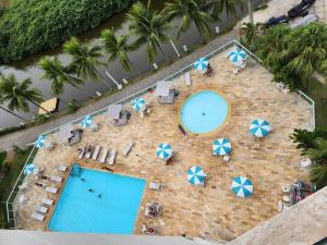 an overhead view of a pool with chairs and umbrellas at Apart Hotel Alecrim Praia de Camboinhas com Marina pe na areia in Niterói