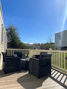 a patio with chairs and a table on a deck at Haven - Hafan Y Mor (Pwllheli) in Pwllheli