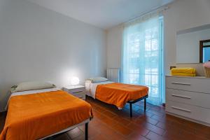 a bedroom with two beds and a window at Mary Rose Apartments in Oliveto Lario