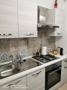 Il comprend une cuisine équipée d'un évier et d'une cuisinière. dans l'établissement Dimora OltreMare, à Bari