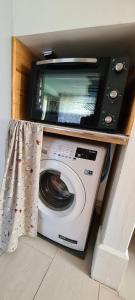 a microwave sitting on top of a washing machine at Au bout du lac d'Annecy in Doussard