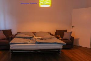 a bed sitting in a living room with a couch at Freundliche Wohnung mit Parkplatz und Terrasse in Neubrandenburg