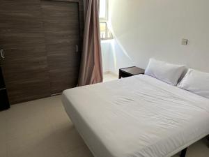 una camera con un letto bianco e una finestra di HOTEL NAKHIL a Nouadhibou