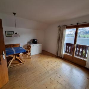 a living room with a table and a large window at Ladner am See in Grundlsee