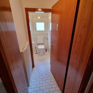 a hallway to a bathroom with a toilet in it at Ladner am See in Grundlsee