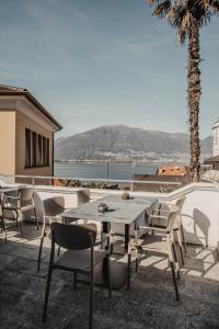 een tafel en stoelen op een patio met uitzicht op de oceaan bij Albergo Ristorante Al Portico in Gerra