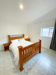 a bedroom with a wooden bed and a window at LCF Rosehill Accommodation 3 free car parking inside property G2 in Sydney