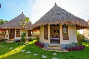 a house with a thatched roof and a yard at White House of Tanzania in Arusha