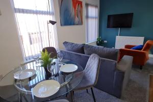 a living room with a couch and a table and chairs at Bury Stays in Bury